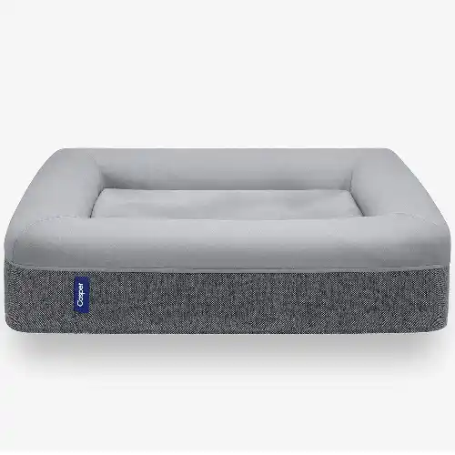 A modern gray dog bed with raised cushioned edges and a supportive flat center, featuring a two-tone fabric design, placed against a plain background for a clean and minimal look.
